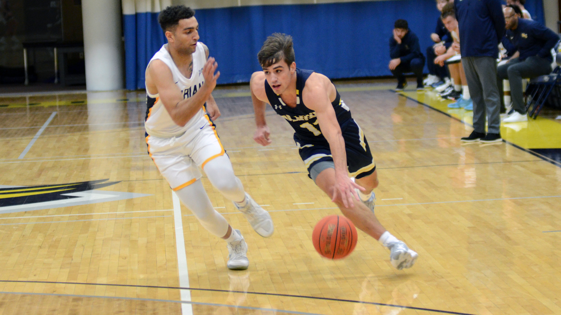Clarke's Anthony Eddy driving past his defender towards the basket